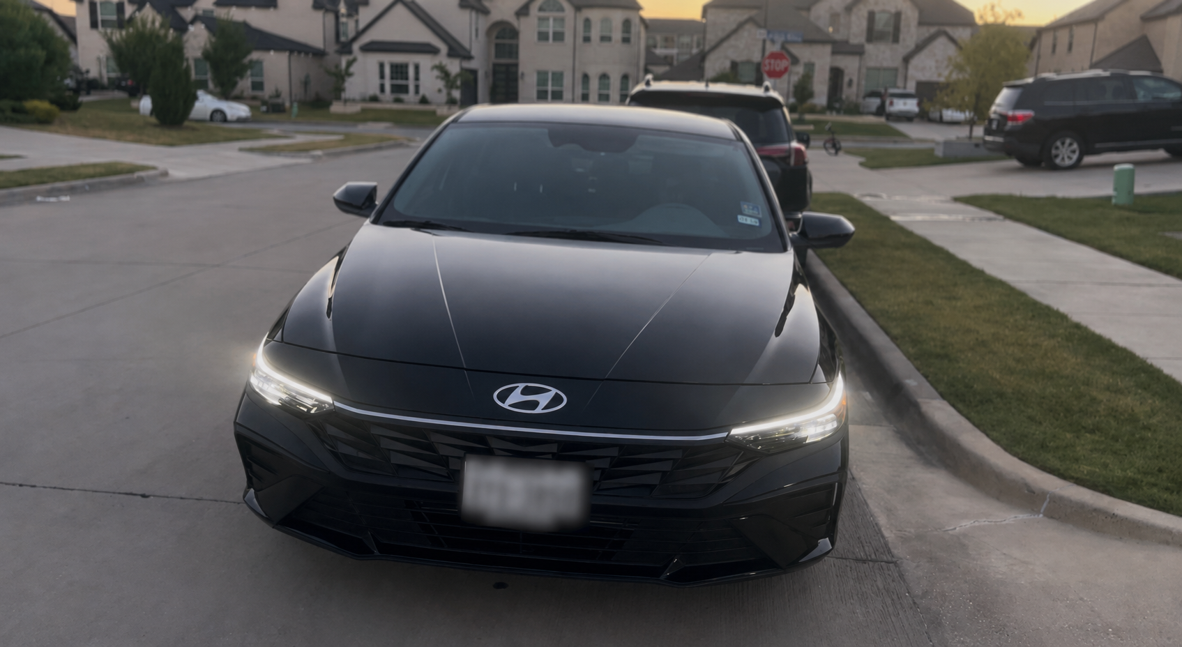 Black sedan with glossy sealed paint after a ceramic spray sealant application in a driveway